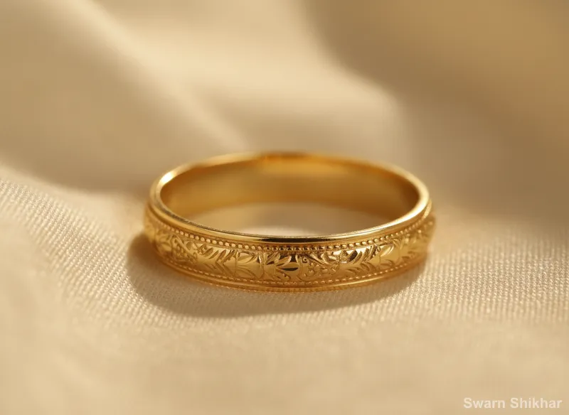 Gold band with a carved pattern around it, on cream fabric